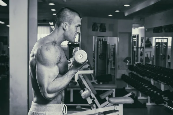 O homem no ginásio bombeando músculos abdominais em um simulador especial . — Fotografia de Stock
