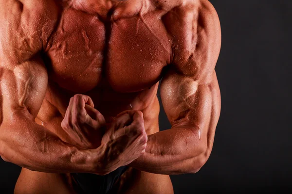 Musclé sur un fond noir — Photo