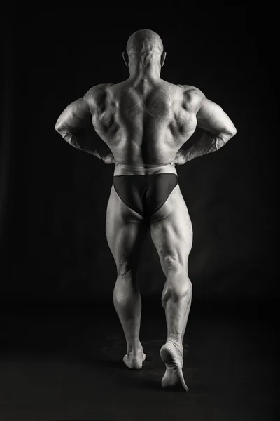 Muscoloso su uno sfondo nero — Foto Stock