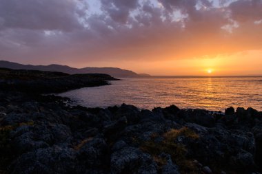 Akşam denizde güzel gün batımı kayalar ön planda