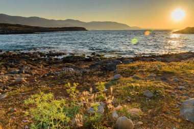 Akşam denizde güzel gün batımı kayalar ön planda