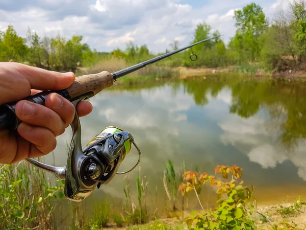 A pescar no lago. Carretel giratório e em um fundo de lago — Fotografia de Stock