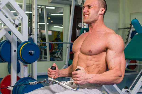 Un homme fort est engagé sur un simulateur dans la salle de gym — Photo