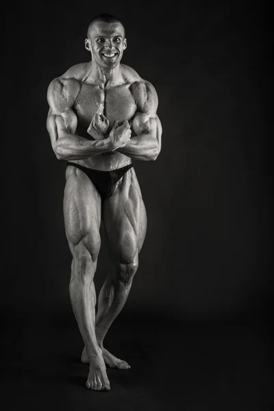Sehr muskulös schöner athletischer Mann auf schwarzem Hintergrund — Stockfoto