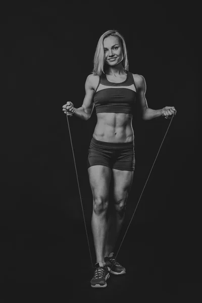 Fitness dívka pózuje na černém pozadí — Stock fotografie