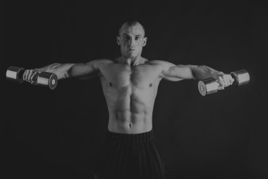 Bir adam bir dumbbell siyah bir arka plan ile