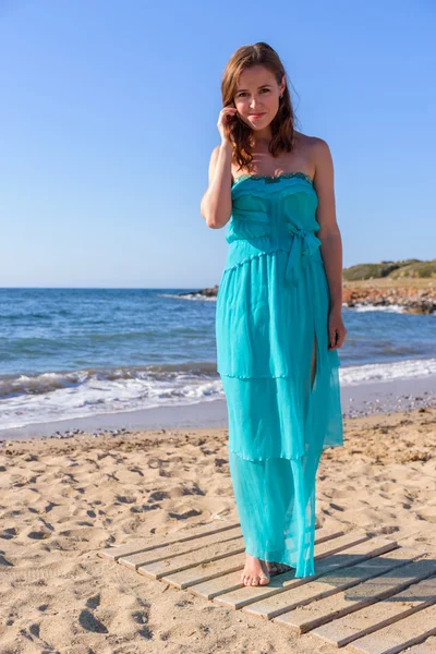 Mavi elbiseli bir sahilde güzel bir kız. Boş deniz at — Stok fotoğraf