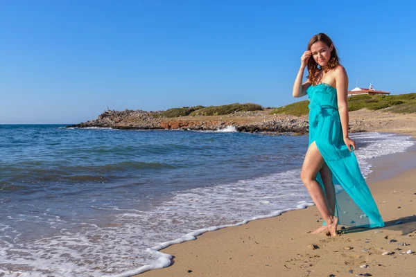 Schöne Mädchen am Strand in einem blauen Kleid. Freizeit auf See — Stockfoto