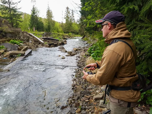 Un pêcheur attrapé truite sur la rivière de montagne — Photo