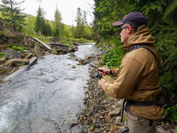 Un pescatore catturato trota sul fiume di montagna — Foto Stock