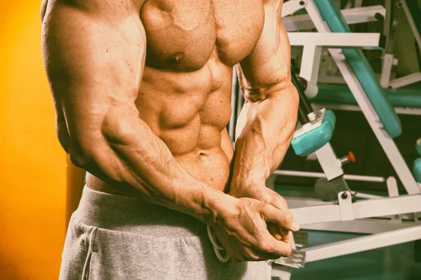 Hermoso cuerpo masculino en el fondo del gimnasio —  Fotos de Stock