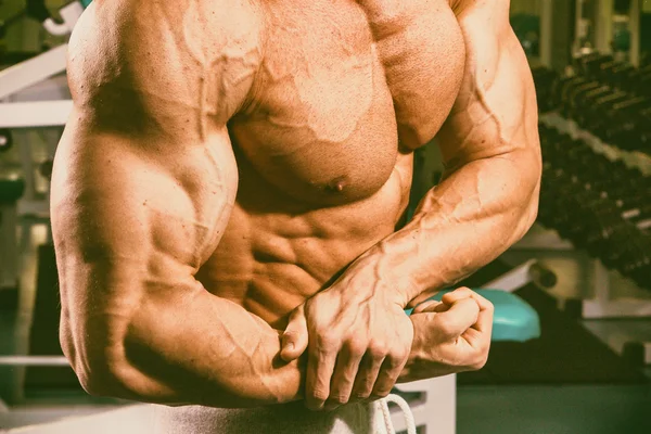 Hermoso cuerpo masculino en el fondo del gimnasio — Foto de Stock