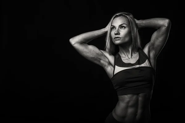 Vrouw bodybuilder op zwart — Stockfoto