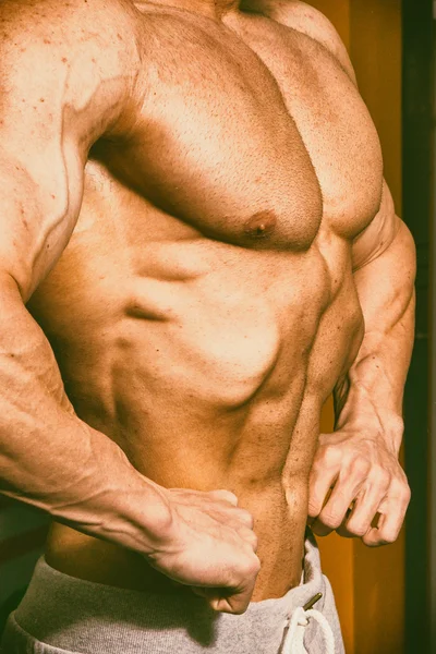 Bellissimo corpo maschile sullo sfondo della palestra — Foto Stock