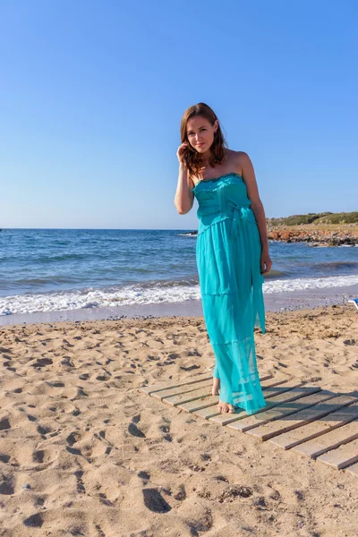 Belle fille sur la plage dans une robe bleue. Loisirs en mer — Photo