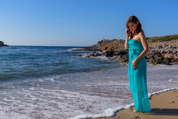 Schöne Mädchen am Strand in einem blauen Kleid. Freizeit auf See — Stockfoto