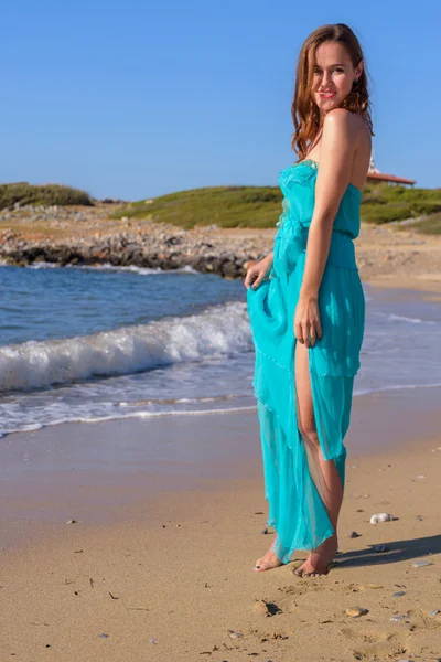 Belle fille sur la plage dans une robe bleue. Loisirs en mer — Photo