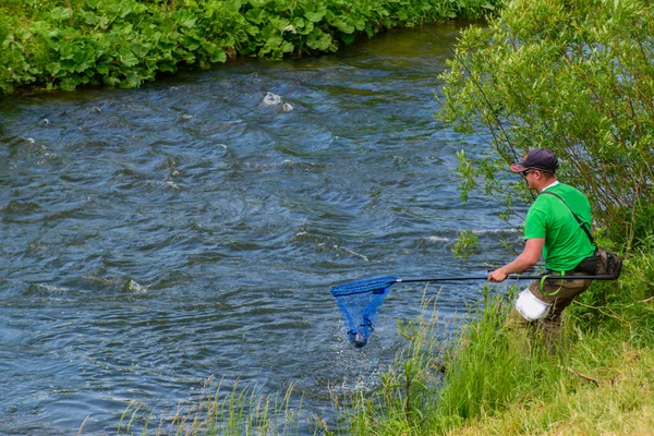 Pescador pescando en un río rápido — Foto de Stock