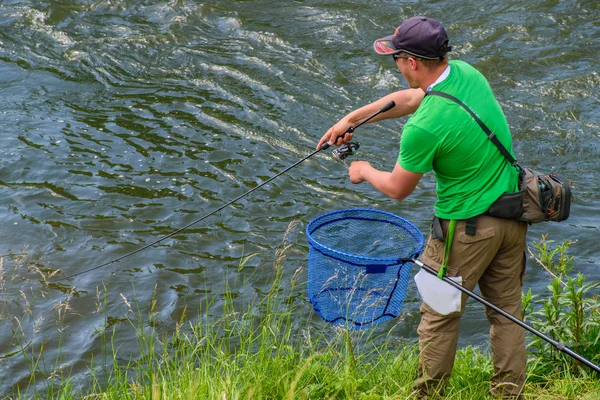 Pescatore pesca in un fiume rapido — Foto Stock