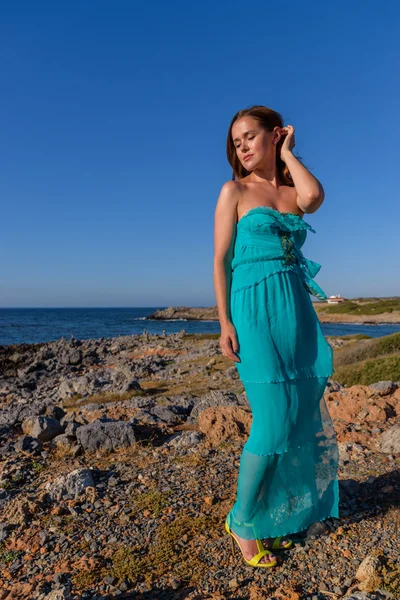 Vacker flicka på stranden i en blå klänning. Fritid vid havet — Stockfoto