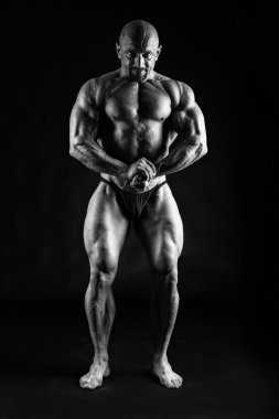 Siyah üzerine poz vücut geliştirmeci