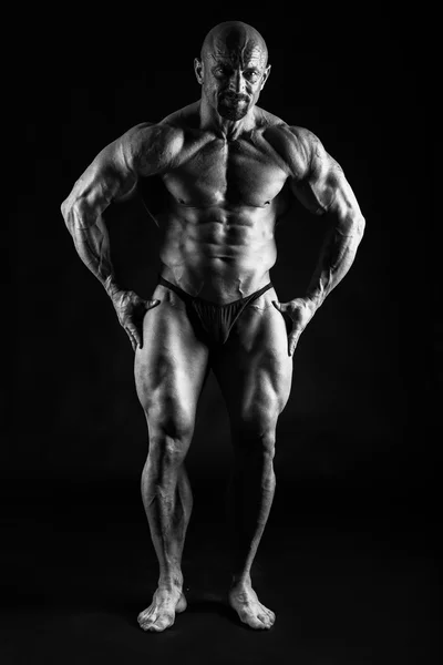 Bodybuilder posing on black — Stock Photo, Image