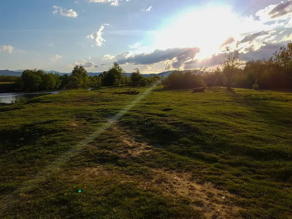 Paisagem montanhosa com rio ao pôr do sol — Fotografia de Stock