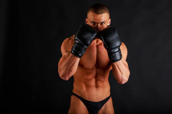 Bodybuilder en gants de boxe sur noir — Photo
