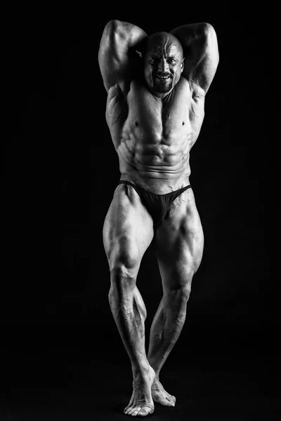 Bodybuilder που παρουσιάζουν σε μαύρο — Φωτογραφία Αρχείου
