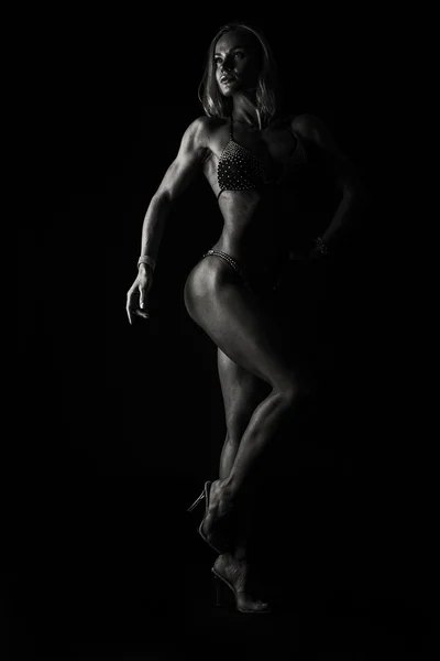 Elegante donna bodybuilder su nero — Foto Stock