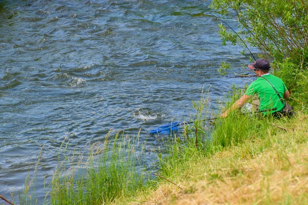 Pescatore pesca in un fiume rapido — Foto Stock