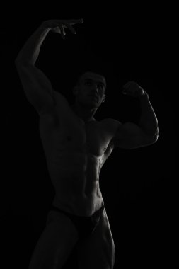 Siyah arka plan üzerinde zarif, kaslı erkek vücut