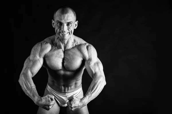Bodybuilder που θέτουν σε διαφορετικές πόζες που αποδεικνύουν τους μυς τους. Αποτυχία σε σκούρο φόντο. Ανδρική προβολή μυς στράγγισμα. Όμορφο μυώδες σώμα αθλητής. — Φωτογραφία Αρχείου