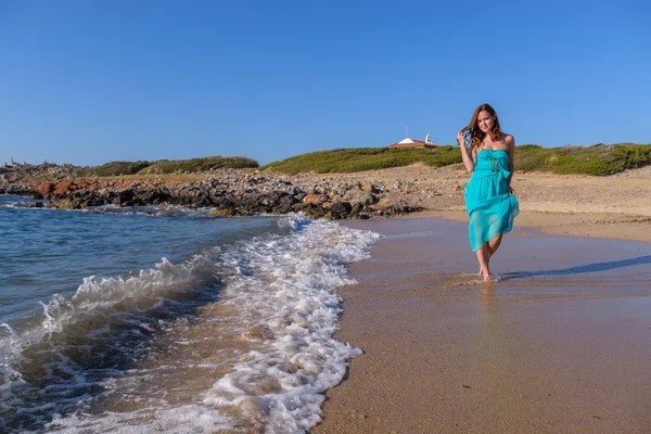 Schöne Mädchen am Strand in einem blauen Kleid. Freizeit auf See — Stockfoto