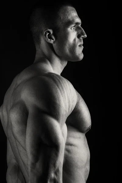 Eleganter, muskulöser männlicher Körper auf schwarzem Hintergrund — Stockfoto