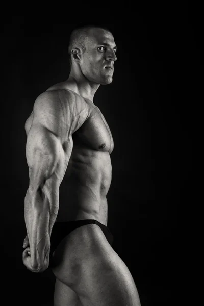 Elegante, muscoloso corpo maschile su sfondo nero — Foto Stock