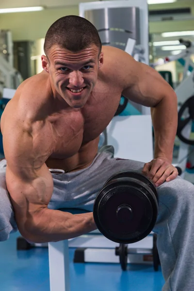 Bodybuilder with dumbbells in fitness club — Stock Photo, Image