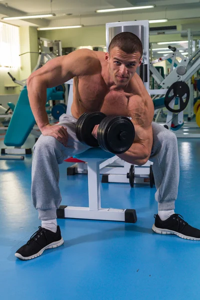 Culturista con mancuernas en gimnasio — Foto de Stock