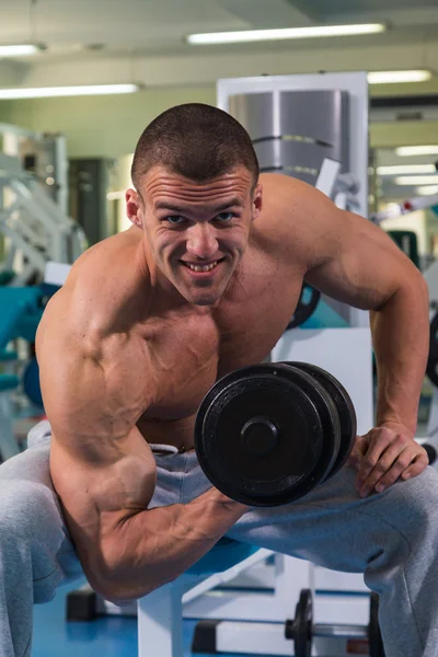 Bodybuilder with dumbbells in fitness club — Stock Photo, Image