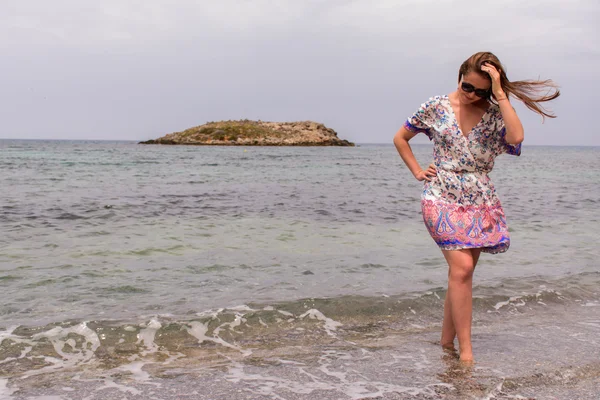 Schöne Frau, die am schönen Strand spaziert — Stockfoto
