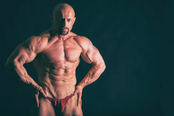 Muskulöser Mann auf schwarz — Stockfoto