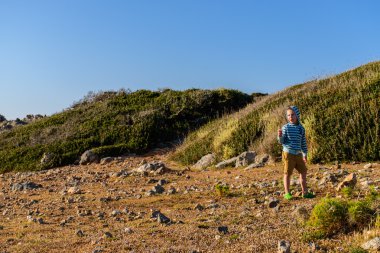 Beş yaşında kayalık arazide yürüyen bir çocuk