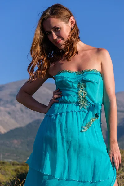 Vacker flicka på stranden i en blå klänning. Fritid vid havet — Stockfoto