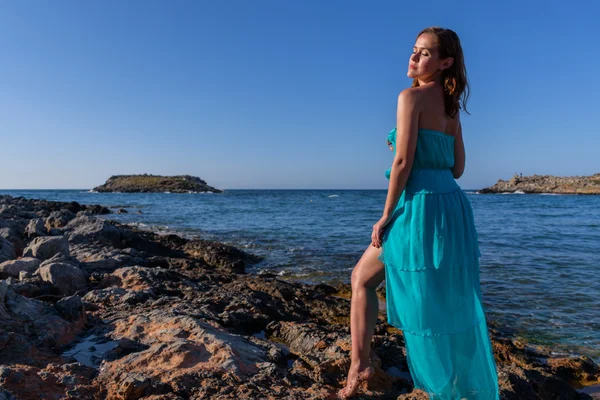 Schöne Mädchen am Strand in einem blauen Kleid. Freizeit auf See — Stockfoto