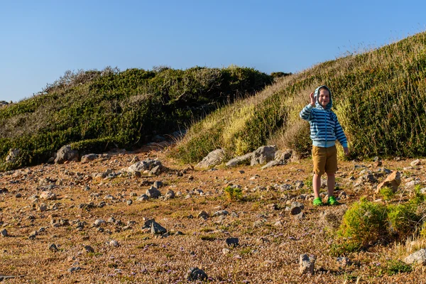 Ein fünfjähriger Junge, der in felsigem Gelände unterwegs ist — Stockfoto