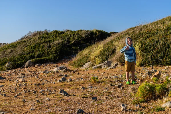 Ein fünfjähriger Junge, der in felsigem Gelände unterwegs ist — Stockfoto