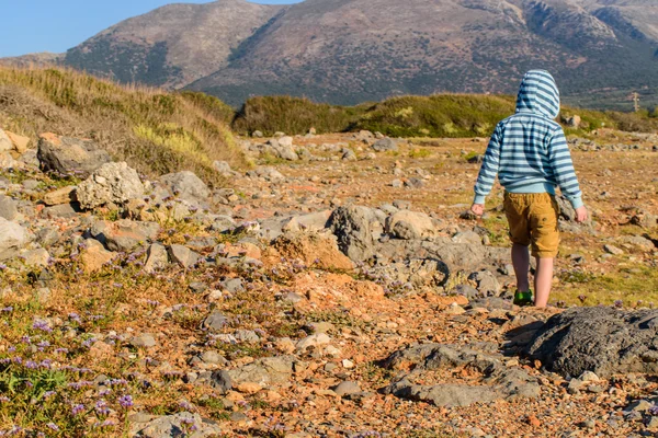 Ein fünfjähriger Junge, der in felsigem Gelände unterwegs ist — Stockfoto