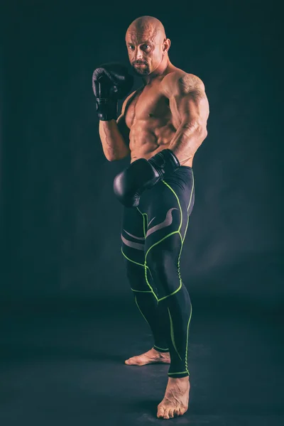 Självsäker bodybuilder på en mörk bakgrund. — Stockfoto