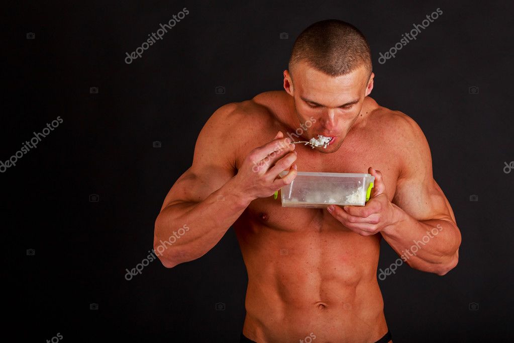 Bodybuilder eats rice on a dark background. Stock Photo by ©aallm 116534020