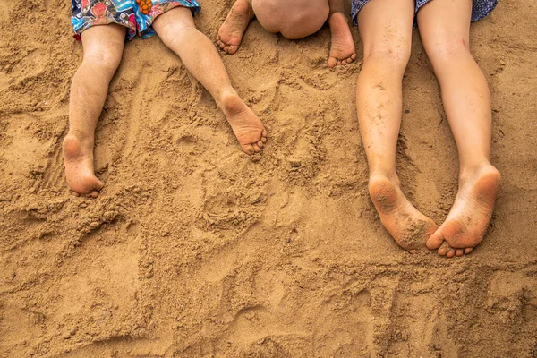 Children's feet on the sand on the sea beach